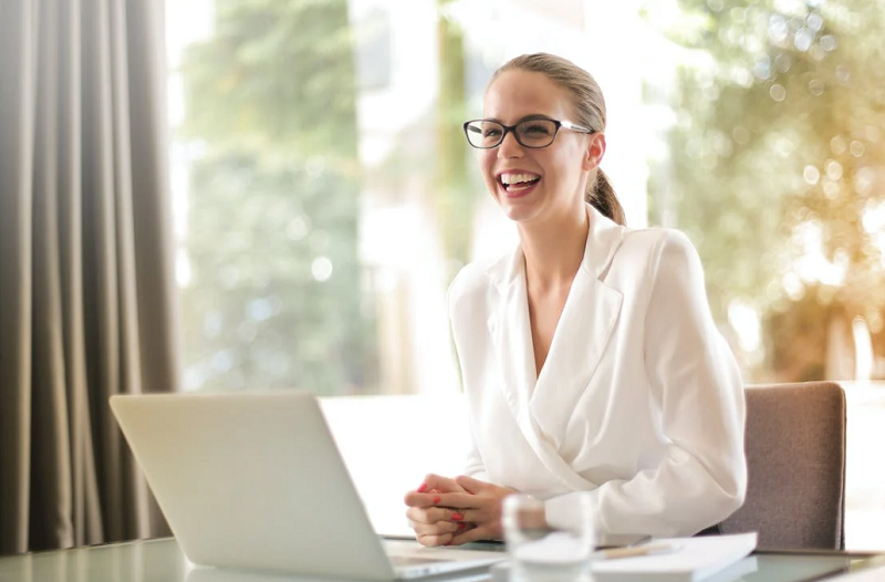 Woman dressed in white sitting on desk